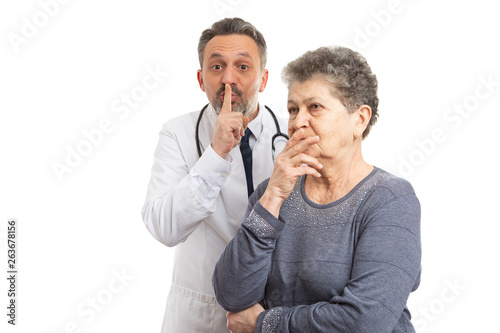 Doctor making shush gesture behind patient