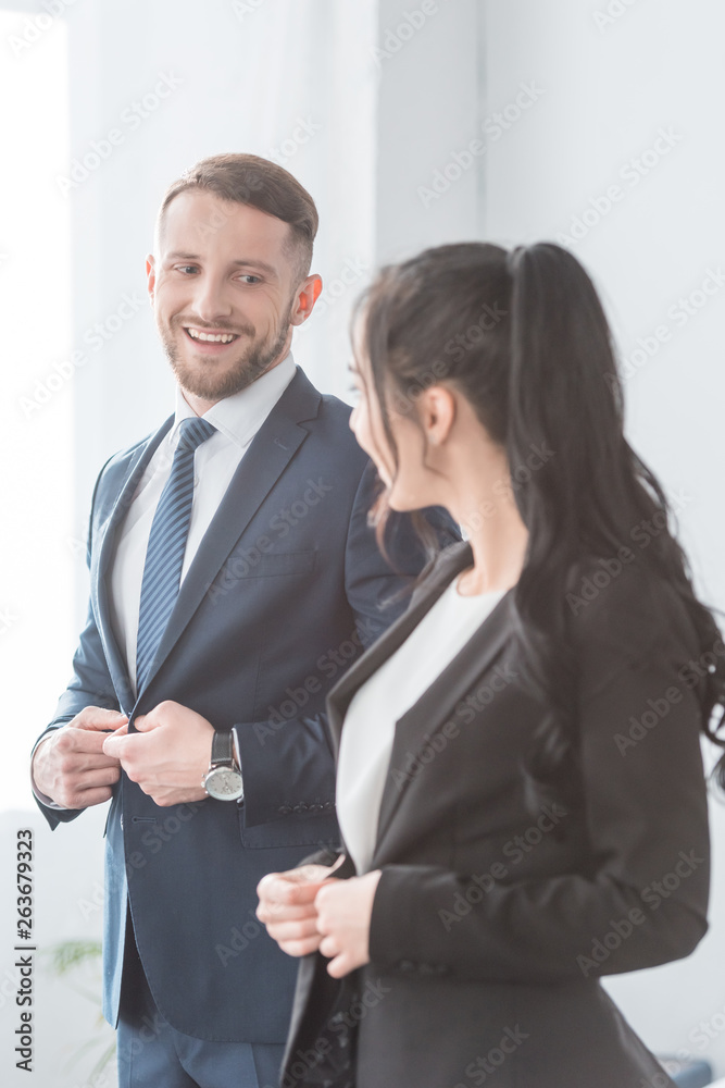 cheerful bearded man looking at brunette woman while touching formal wear cheerful bearded man looking at brunette woman while touching formal wear