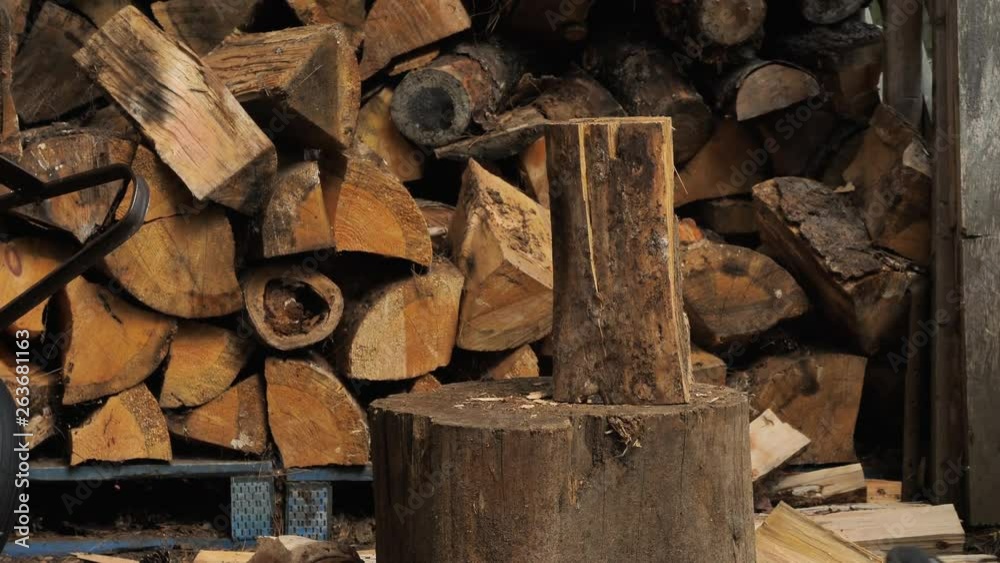 Close up of a man splitting a log with a felling axe. Close up of a man splitting a log with a felling axe.