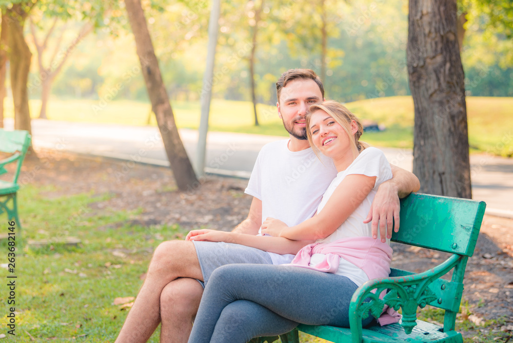 Fototapeta premium Portrait of Young couple enjoying in the park at sunset. Concept romantic and love. Warm tone.