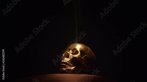 A gold skull lying in the dark