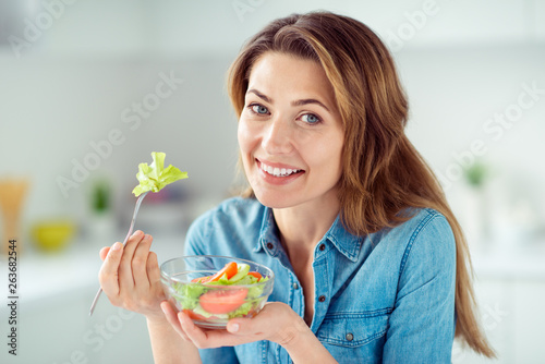 Close-up portrait of her she nice-looking lovely charming cute attractive shine cheerful cheery positive brown-haired lady tasting detox vitamin salad in light white interior style kitchen
