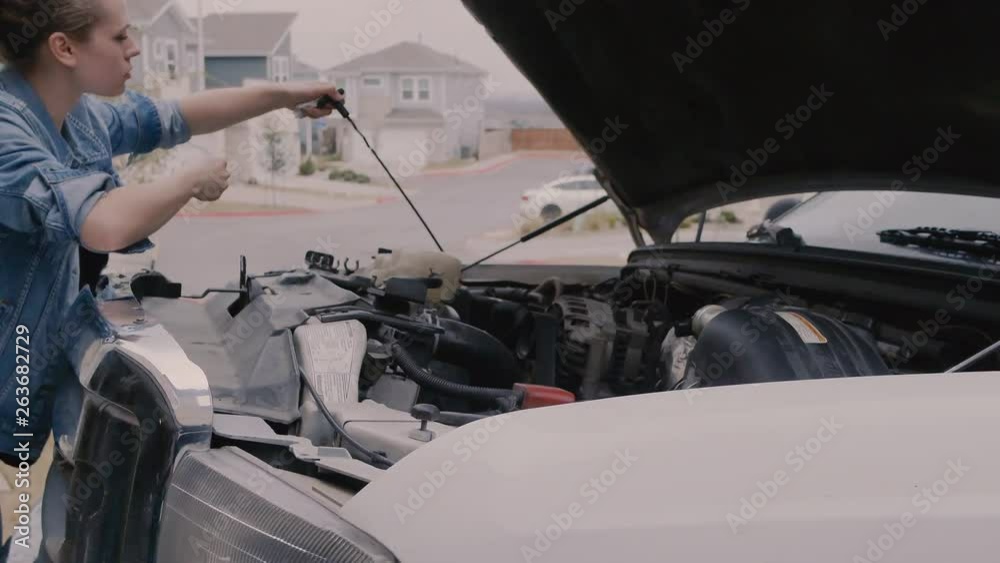 Woman working on vehicle, checking oil, under the hood, checking the engine, opening the hood, vehicle maintenance, looking at oil, inspection, Woman working on vehicle, checking oil, under the hood, checking the engine, opening the hood, vehicle maintenance, looking at oil, inspection,