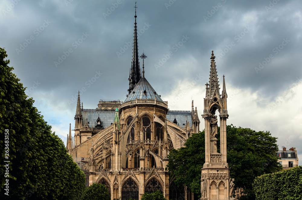 Notre-Dame de Paris cathedral under cloudy sky.