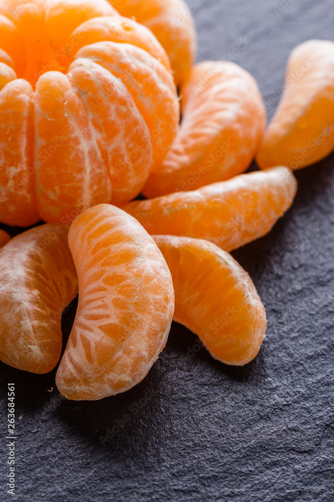 juicy mandarin on a dark stone background juicy mandarin on a dark stone background