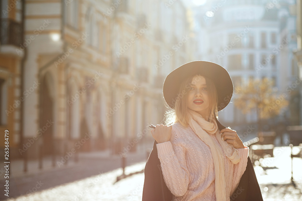 Fototapeta premium Closeup portrait of amazing blonde woman wearing hat and sweater posing with sun light. Empty space