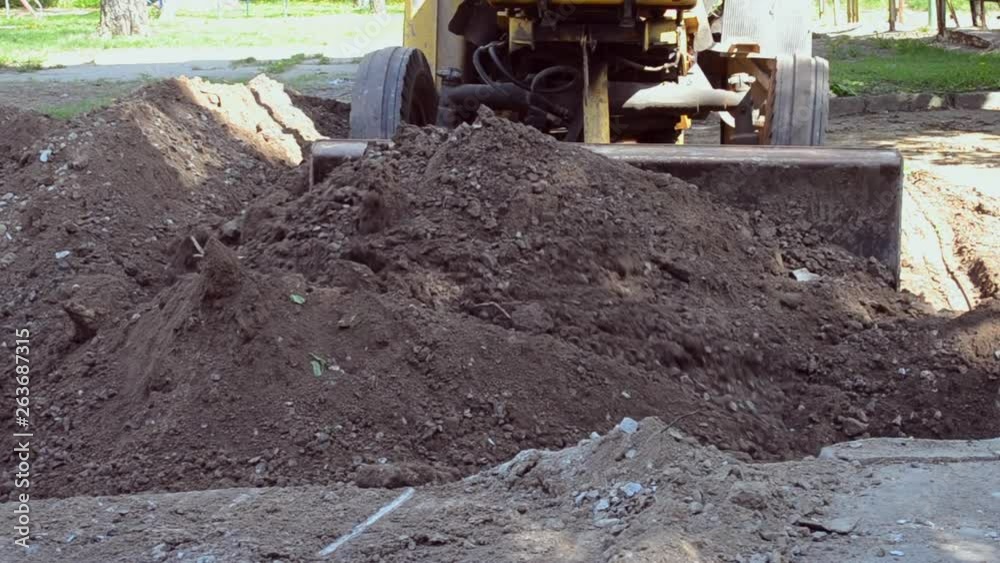 Tractor removes soil dirt, dig hole construction site. Tractor removes soil dirt, dig hole construction site.