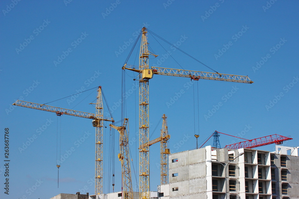 modern construction of multi-storey and apartment buildings. concrete structures for people's lives in the city. build houses. cranes cargo to height for workers. technical help in hard work.