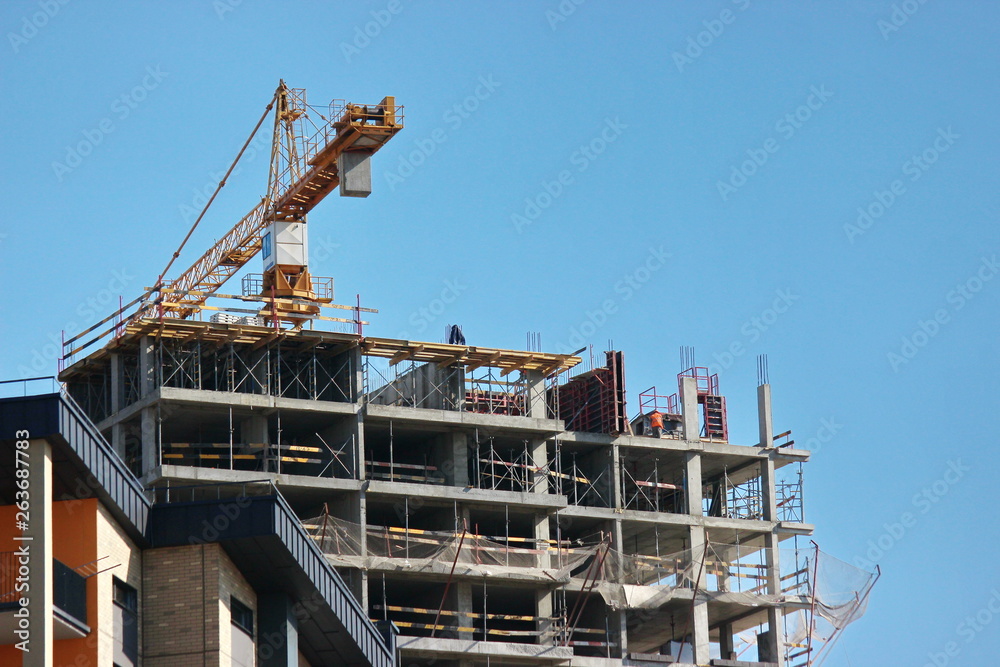 modern construction of multi-storey and apartment buildings. concrete structures for people's lives in the city. build houses. cranes cargo to height for workers. technical help in hard work.