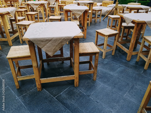 Large Group of Wooden Table with Cloth Covers and Chairs at Outdoor Street Food Restaurant