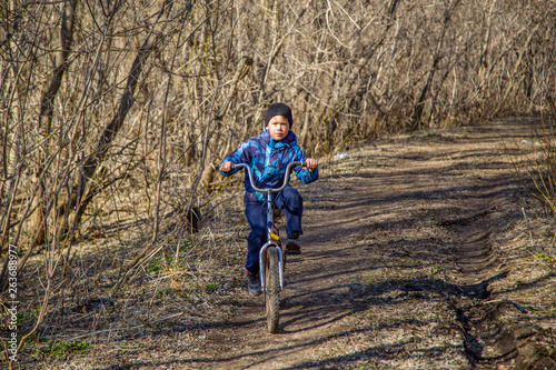 kid rides a bike in the forest