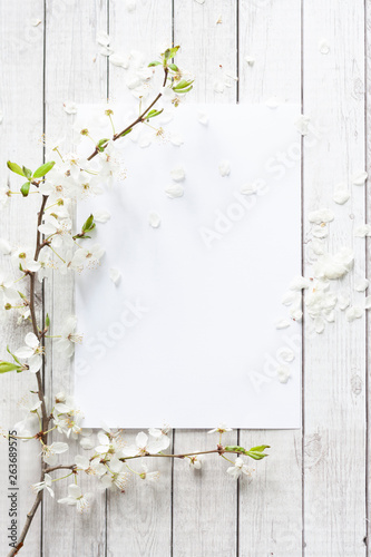 Blank sheet of paper for writing with white spring flowers