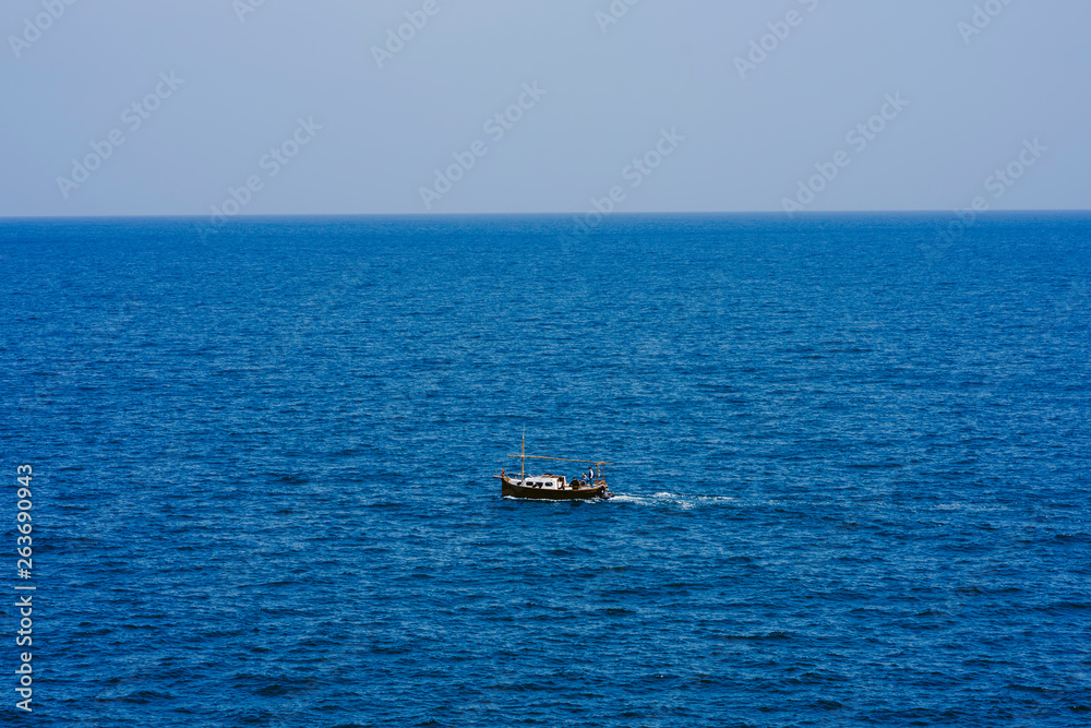 Line of the sea with boat with blue sky completely clear with very soft waves.