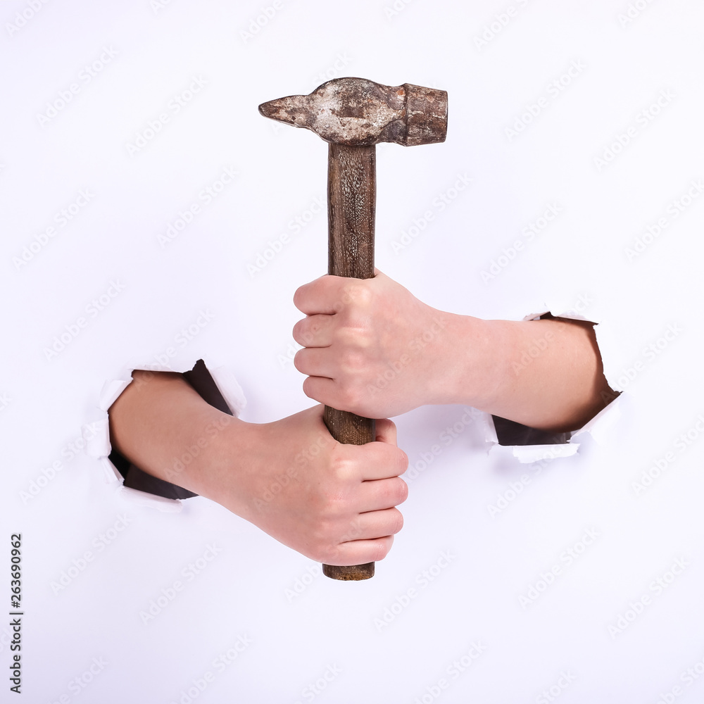 Hammer in the hand of a girl. Symbol of hard work, feminism and labor day. Isolate on white background. Hammer in the hand of a girl. Symbol of hard work, feminism and labor day. Isolate on white background.