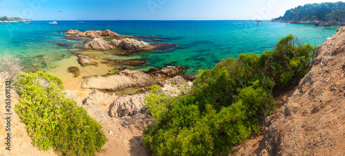 Spain beach. Costa brava resort beach. Rocks in sandy beach Cala Treumal and Santa Cristina in Lloret de Mar