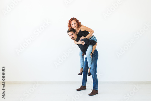People and love concept - Beautiful pretty woman sitting at man's back and embracing him on white background with copy space