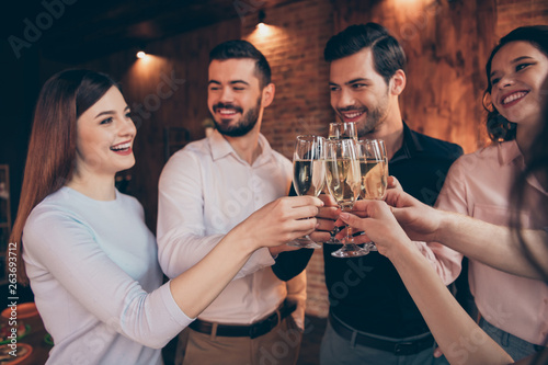 Portrait of nice lovely winsome attractive pretty cheerful cheery positive guys ladies having fun clinking wineglasses greetings congrats congratulate birthday lights in industrial loft interior room