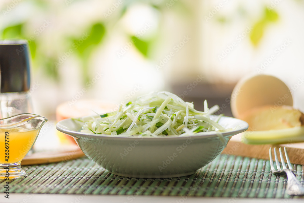 Bowl of vegan healthy raw vegetable salad - daikon radish, celery, cucumber and spring onions - organic cuisine. Close-up. Bowl of vegan healthy raw vegetable salad - daikon radish, celery, cucumber and spring onions - organic cuisine. Close-up.