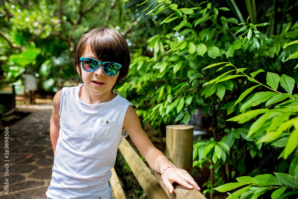 Close portrait of fashion sweet preschool boy in jungle park