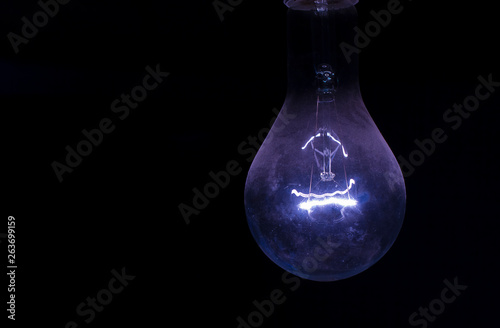  blue vintage incandescent bulb on a black background