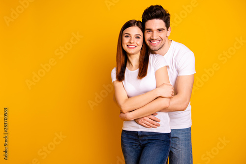 Portrait of his he her she two nice lovely sweet tender attractive cheerful cheery positive people spending time cuddling isolated over vivid shine bright yellow background