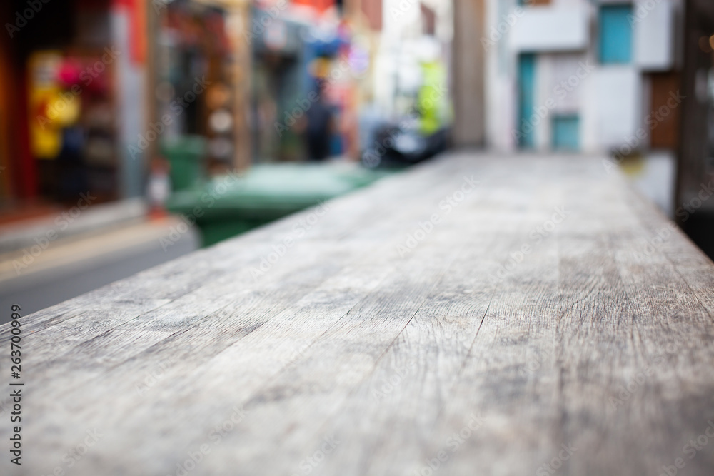 wooden table  and blurred street scene in the background