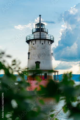 Sleepy Hollow Lighthouse on a beautiful summer's day, against a blue sky, with white clouds and bokeh foliage in the foreground, Sleepy Hollow, Upstate New York, NY