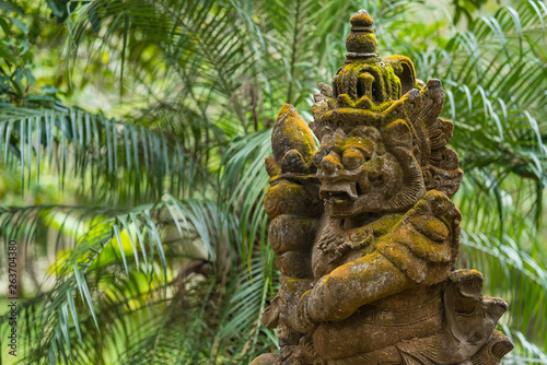 Balinese Carved Stone Statue of Rakasa covered with green moss.Thailand.