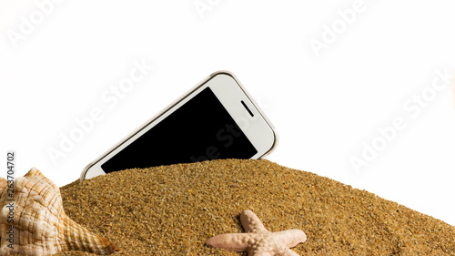 white cell phone black screen buried in sand with shells with a white background