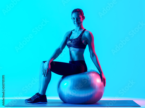 one mixed races woman exercsing fitness pilates exercices isolated on blue blackground photo