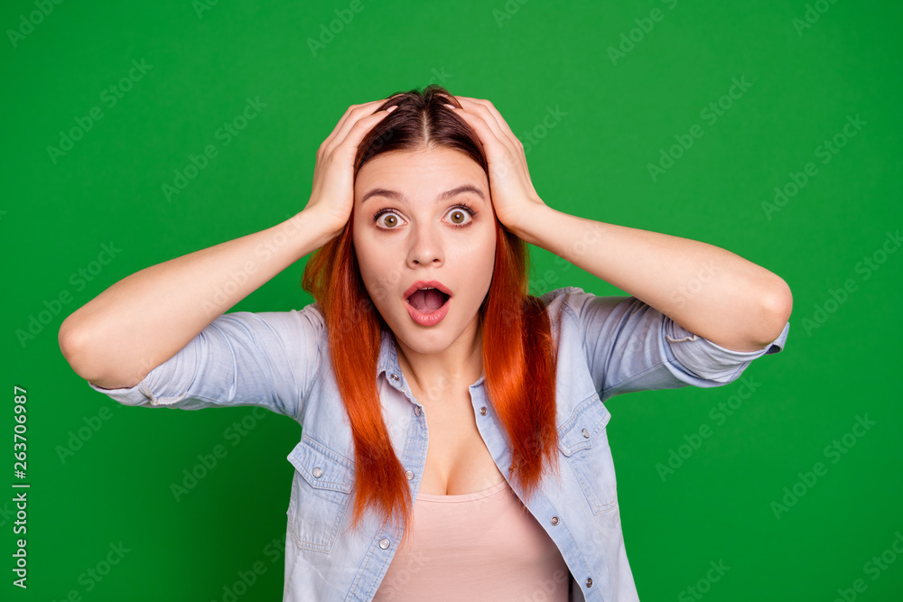 Close up photo beautiful amazing she her lady arms hands hold head open mouth not believe eyes oh no expression epic fail loser lose lost wear casual jeans denim shirt isolated green bright background Close up photo beautiful amazing she her lady arms hands hold head open mouth not believe eyes oh no expression epic fail loser lose lost wear casual jeans denim shirt isolated green bright background