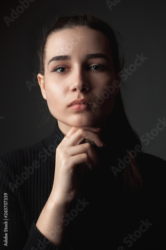 Portrait of the beautiful young woman on the black background