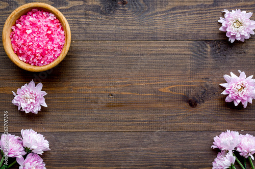 aroma therapy with pink flower fragrance and spa salt on wooden background top view space for text