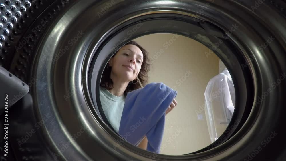 Washing clothes. Pretty woman puts clothes in the washing machine. Washing clothes. Pretty woman puts clothes in the washing machine.