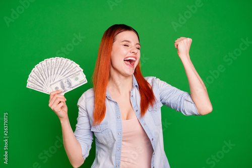 Portrait of positive cheerful satisfied youth content scream aim get wages raise fists ecstatic beautiful stylish close eyes yeah shout dressed jeans outfit long straight hair isolated on ngreen photo