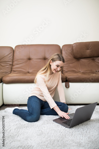 Pretty woman using her laptop at home in the living room