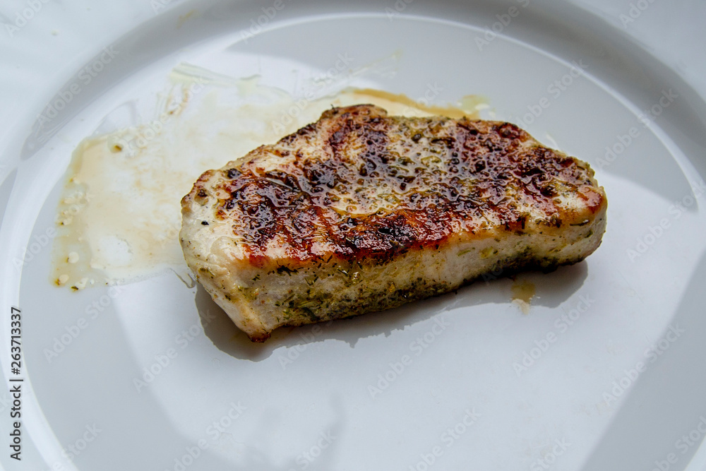 Juicy fried turkey steak in oil and spices on plate