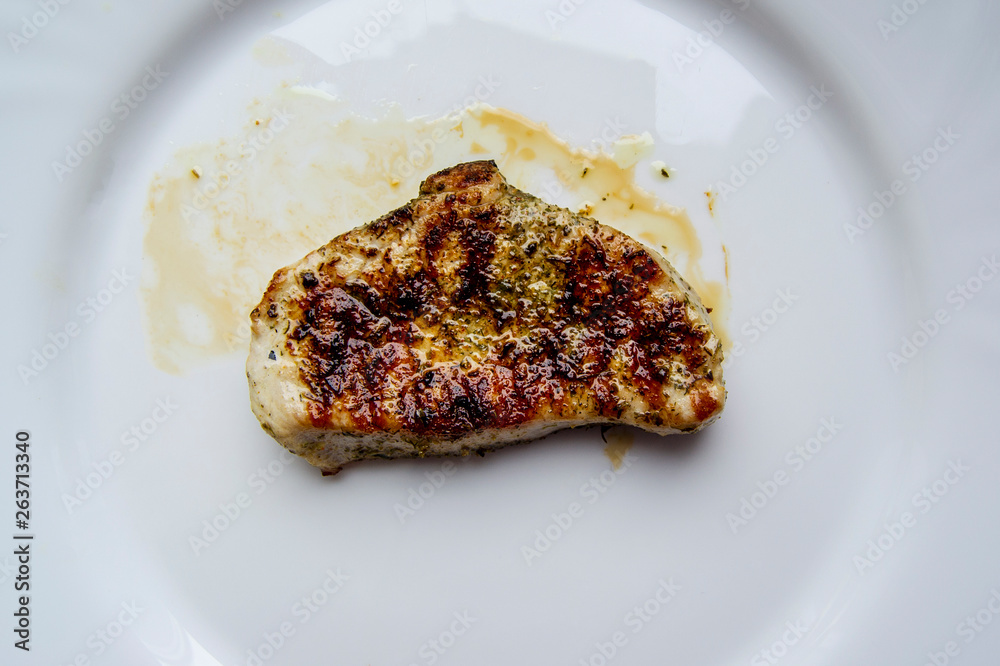 Juicy grilled steak in oil and spices on plate