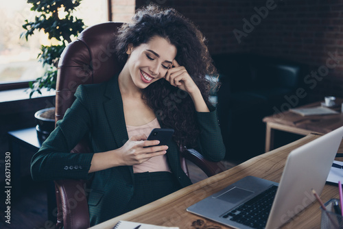 Portrait beautiful stylish trendy millennial cheerful excited ceo pause satisfied search news social network account have dialogue gadget candid content sit armchair pc fashionable jacket industrial
