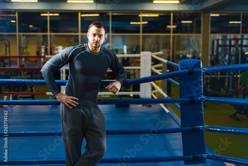 portrait of a young sports guy in the gym. man stands on the boxing ring..