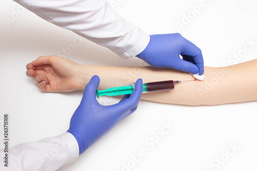 Doctor takes blood from a girl's vein for immunoglobulins and hepatitis, reaction to allergens, copy space, immunogram