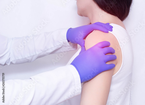 Konstfotografi A doctor examines the sore shoulder of a patient with inflammation and stiffness