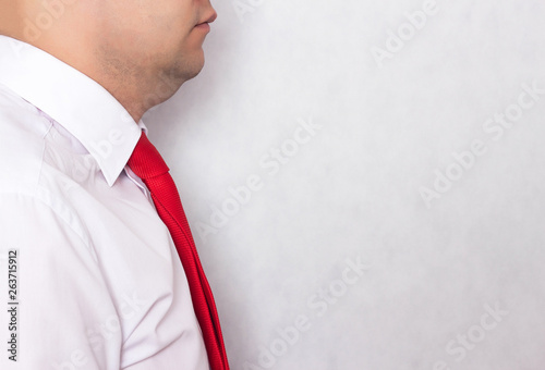 Office worker man in a tie with a problematic double chin on a white background, copy space, weight loss