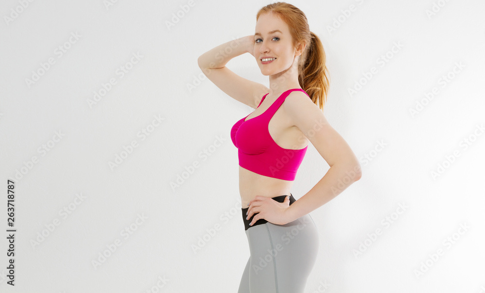 Young red haired girl in sport wear clothes isolated on white background. Slim body figure and healthy lifestyle. Fitness and sports concept. Banner Young red haired girl in sport wear clothes isolated on white background. Slim body figure and healthy lifestyle. Fitness and sports concept. Banner