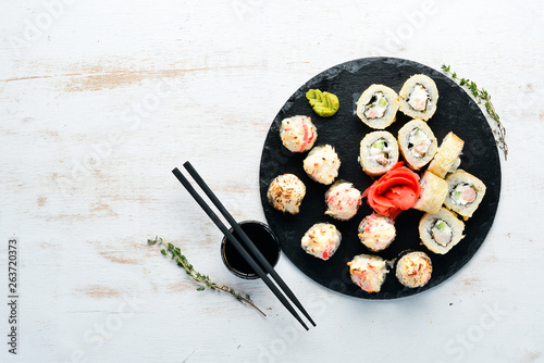 Sushi and maki rolls on a plate. Top view. Free space for your text. On a white background.