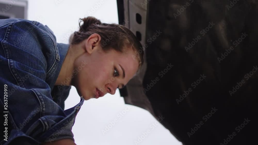 A woman under the hood, fixing her diesel truck at home, 23.98 fps. A woman under the hood, fixing her diesel truck at home, 23.98 fps.