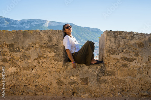 Cuadro en lienzo young woman sitting on the wall