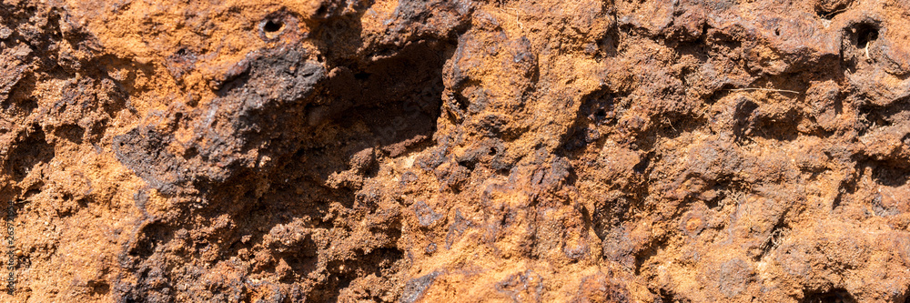 Natural volcanic stone in red and brown. Surface of the volcanic rock. Panoramic image Natural volcanic stone in red and brown. Surface of the volcanic rock. Panoramic image