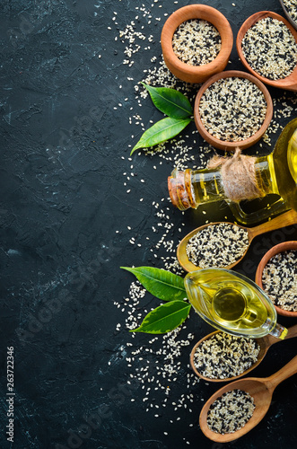 Seeds of sesame and sesame oil. On the old background. Top view. Free copy space.