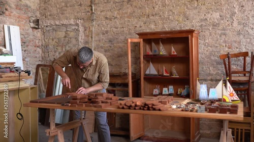 Hardworking crafsman works on small wooden boat photo